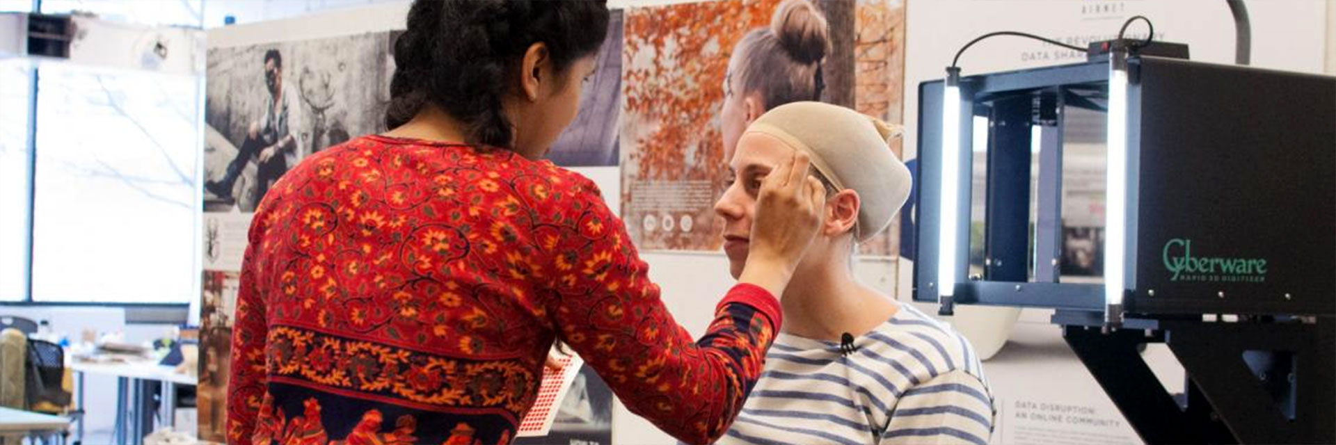A student prepares a fellow student's face for 3D scanning.