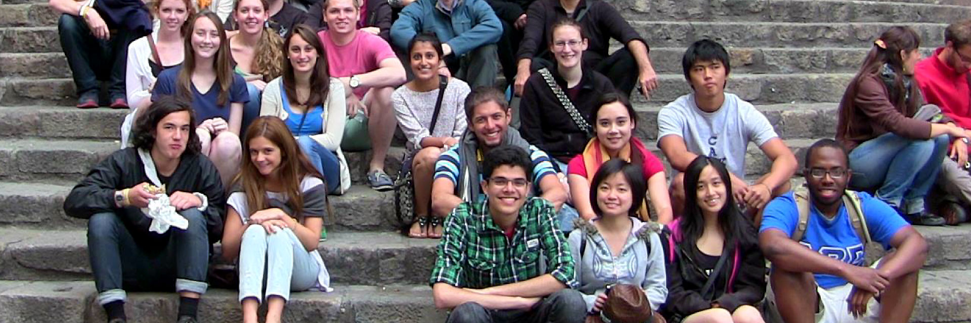 Students studying abroad pose on stone steps in Barcelona, Spain.
