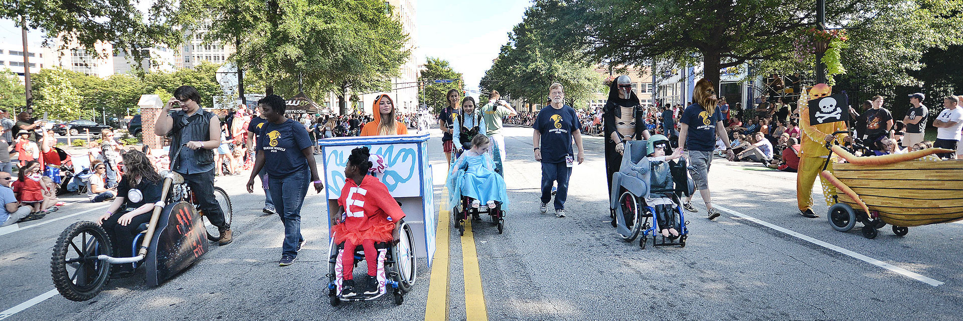 The DragonWheels team of students and children who use wheelchairs march in the Dragon Con parade. 