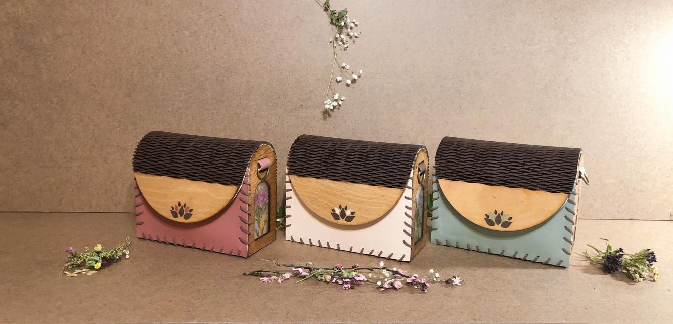 A picture of three nature themed purses against a neutral background.