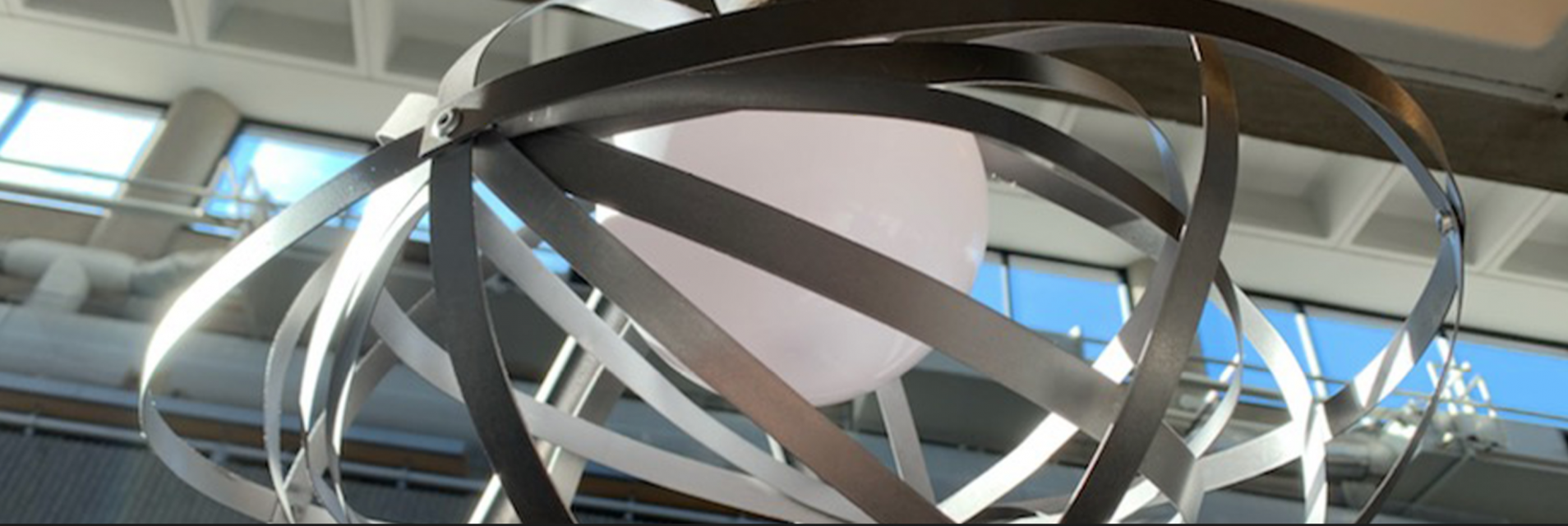 A white sphere surrounded by curving strips of metal.
