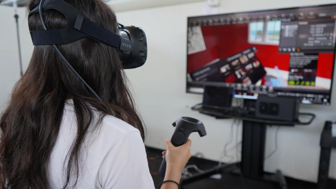 A student interacting with a VR headset. 