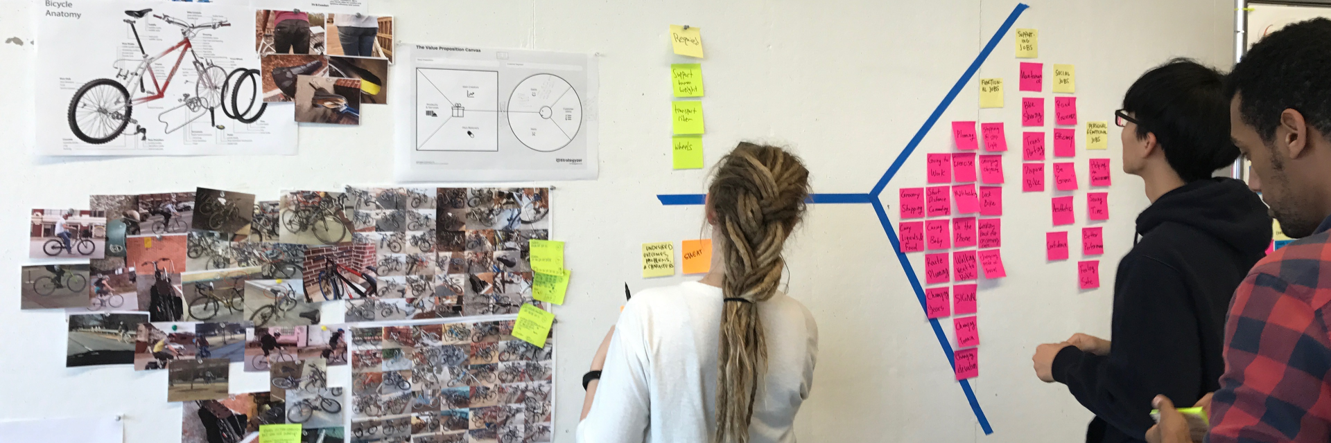 students pinning up research on a pin-up board. 