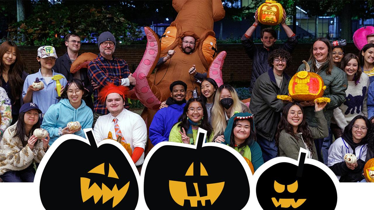 Photo of industrial design students holding up jack-o-lanterns and dressed for halloween.