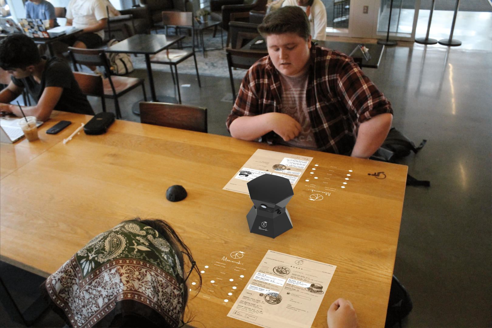 Two students with the menu match device at a table