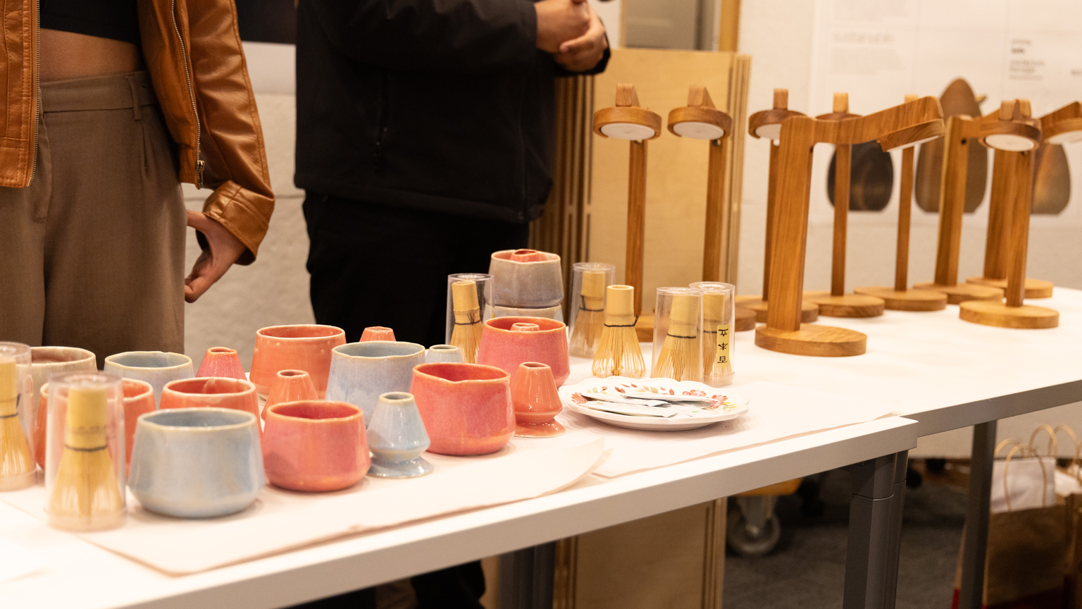 Make 10 products lined up on a table, ready for sale. The left side of the photo shows ceramic pots; the right side shows a combination headphone stand and lamp.